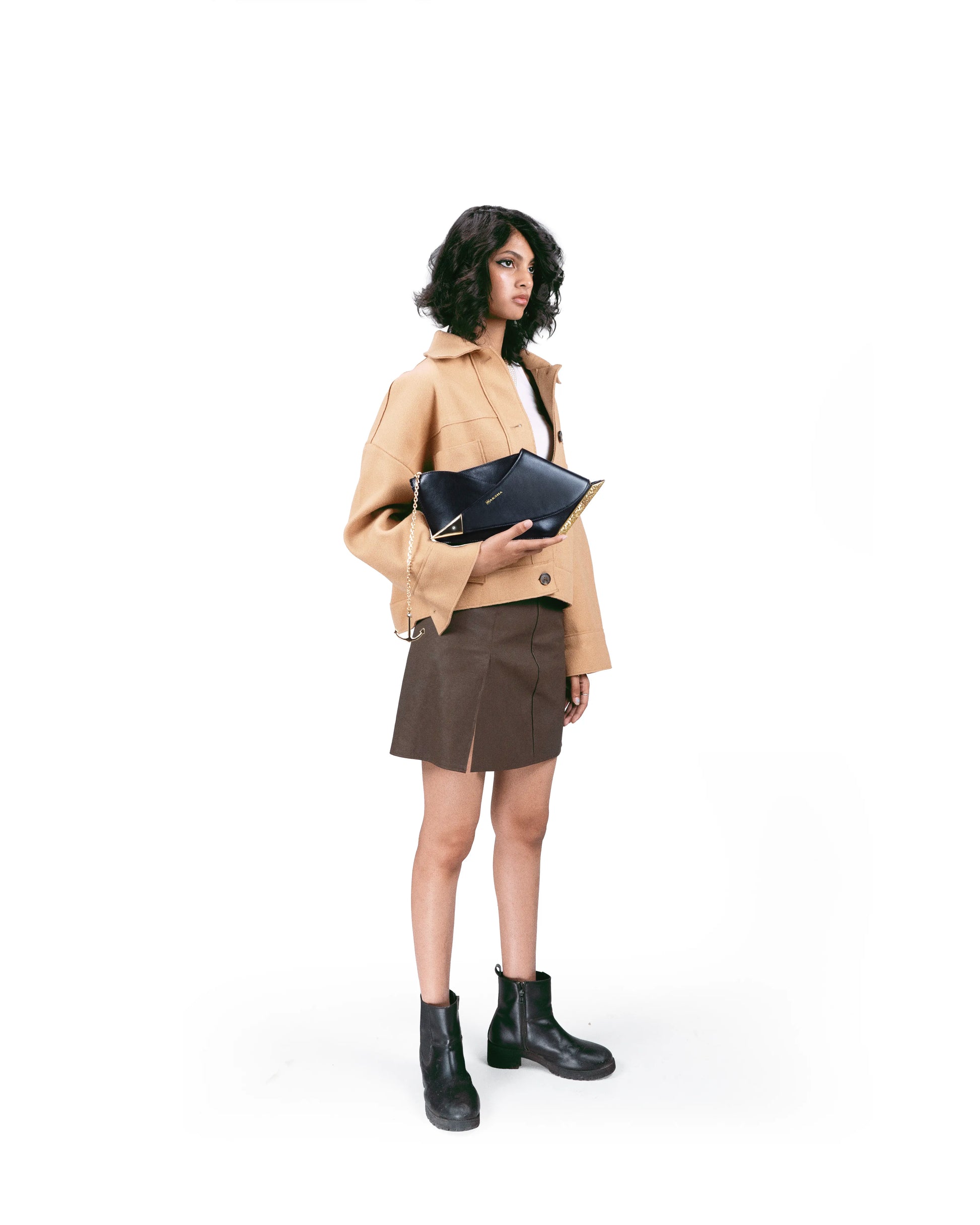 Model wearing Naav — luxury gold-plated black leather shoulder bag